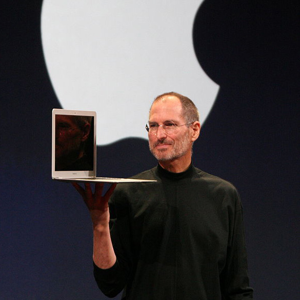 Steve Jobs holding a Mac Book Air