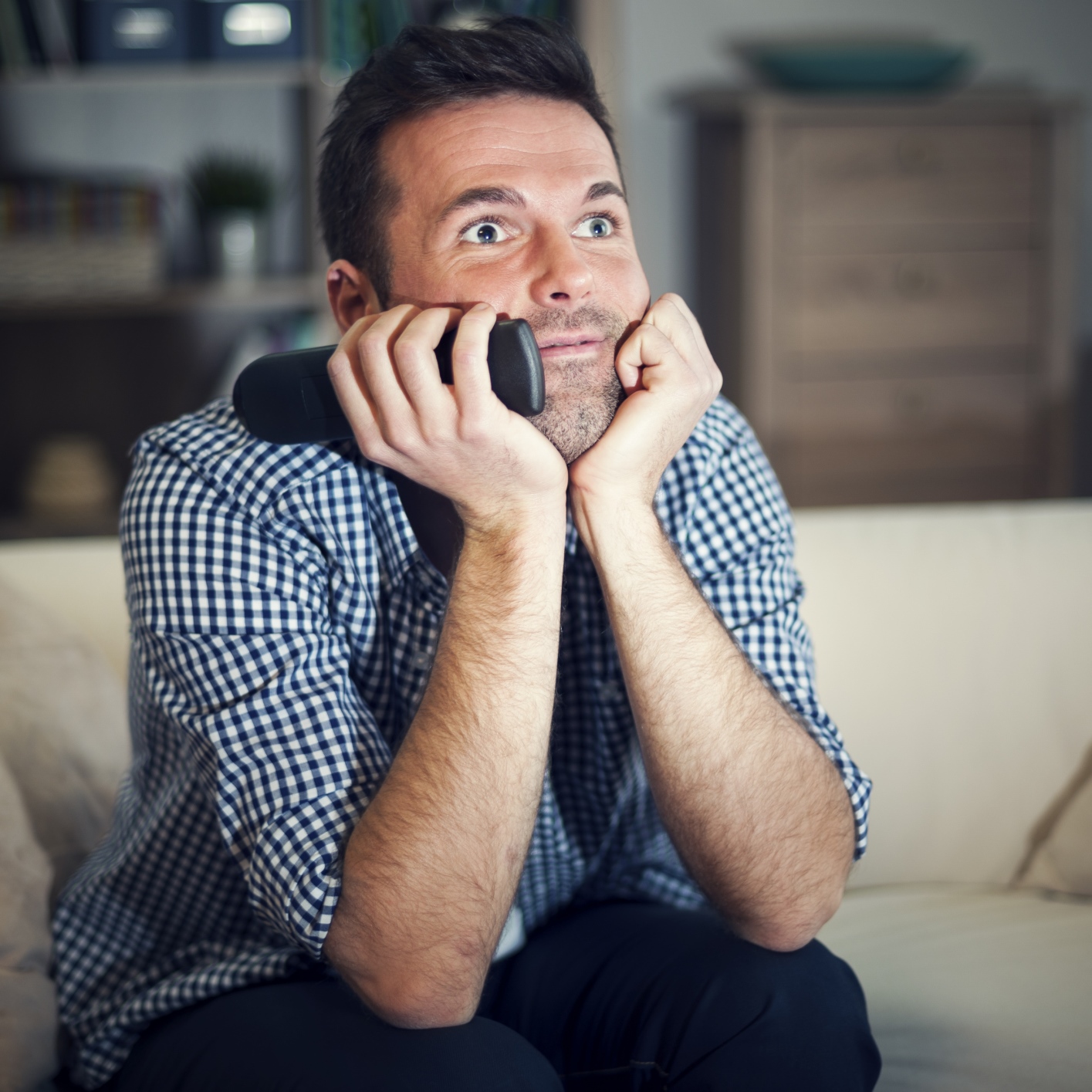 Smiling man watching interesting movie