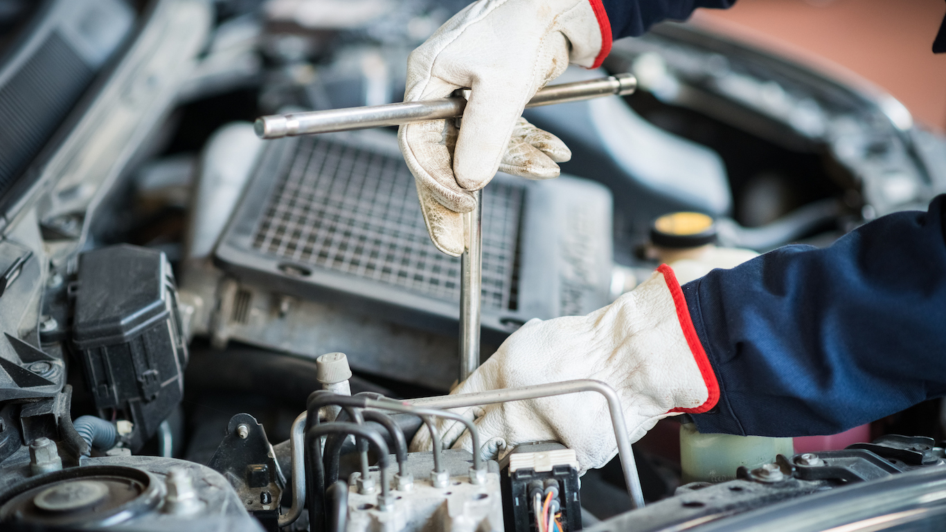 Detail of a mechanic at work on car engine
