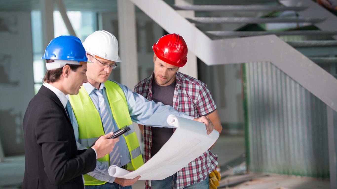 Construction team reviewing blueprints together