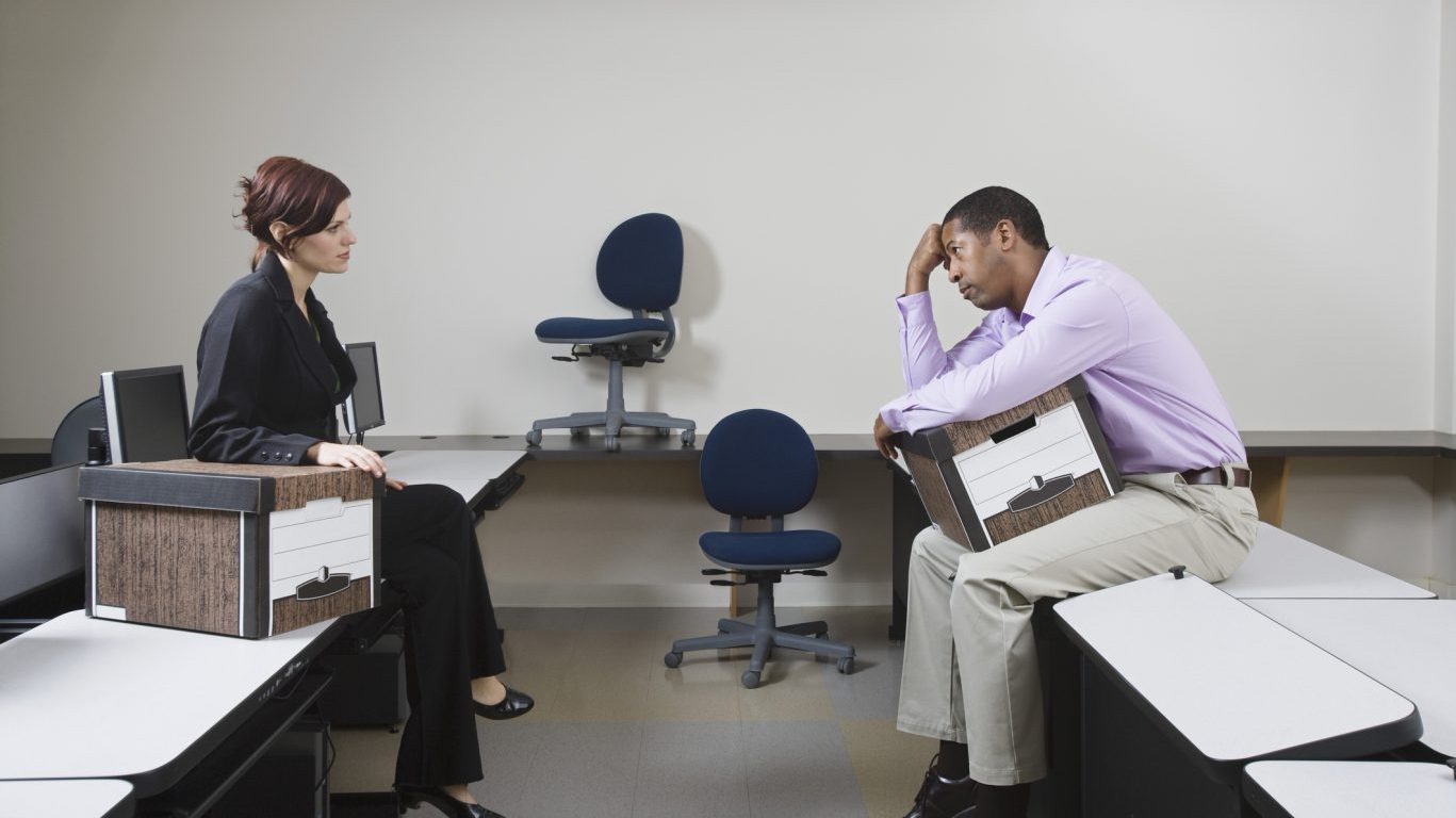 Depressed Man Sitting on Desk with Moving Box