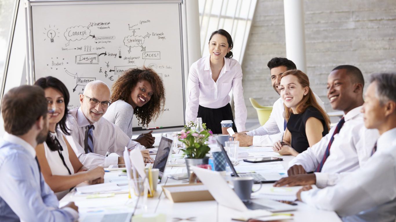 Asian Businesswoman Leading Meeting At Boardroom Table