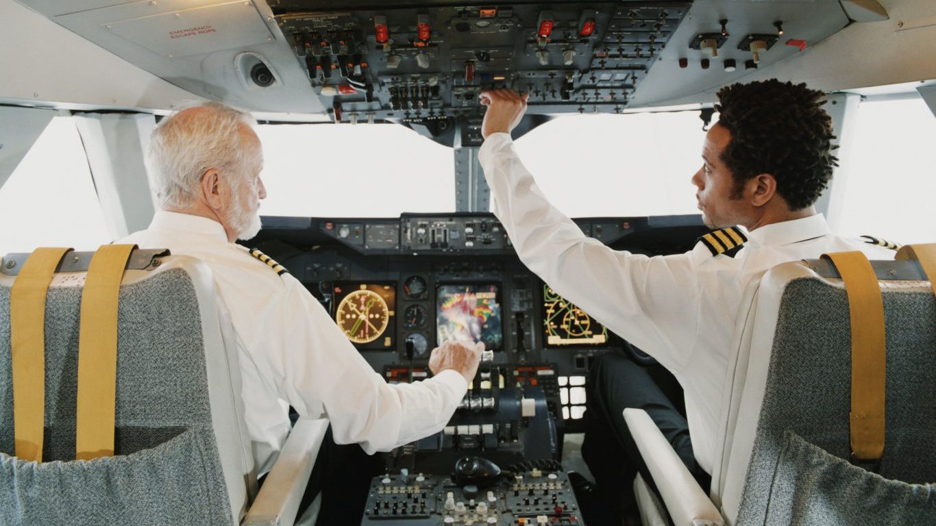 Portrait of Pilots Sitting in the Cockpit, Adjusting the Controls