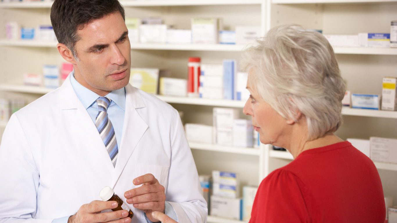 American pharmacist with senior woman in pharmacy