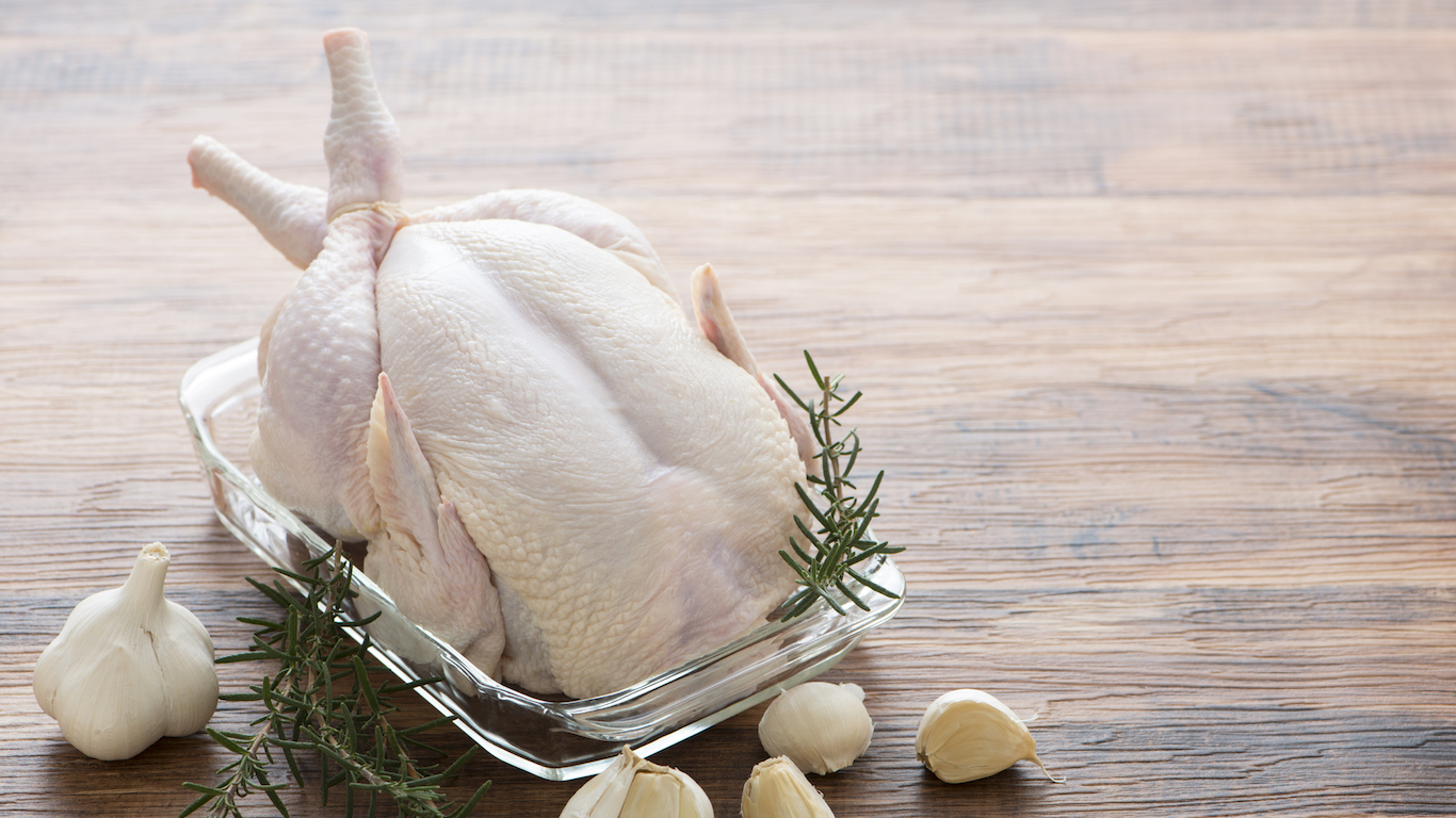 Raw fresh whole chicken with garlic and rosemary