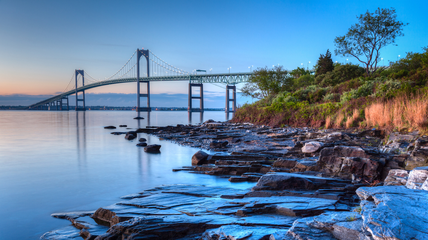 This is a long exposure HDR of the illuminated Newport bridge from Taylor&#039;s Point near Jamestown, Rhode Island, USA. It was taken at sunrise with a rocky seascape in the foreground.