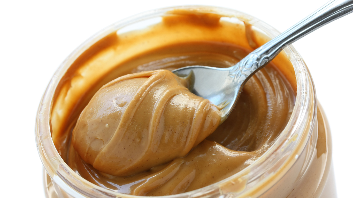 open jar of peanut butter with spoon