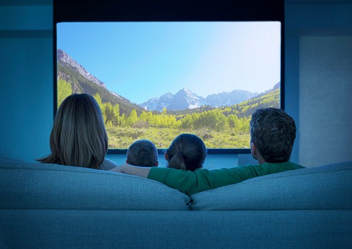 Family watching television in living room