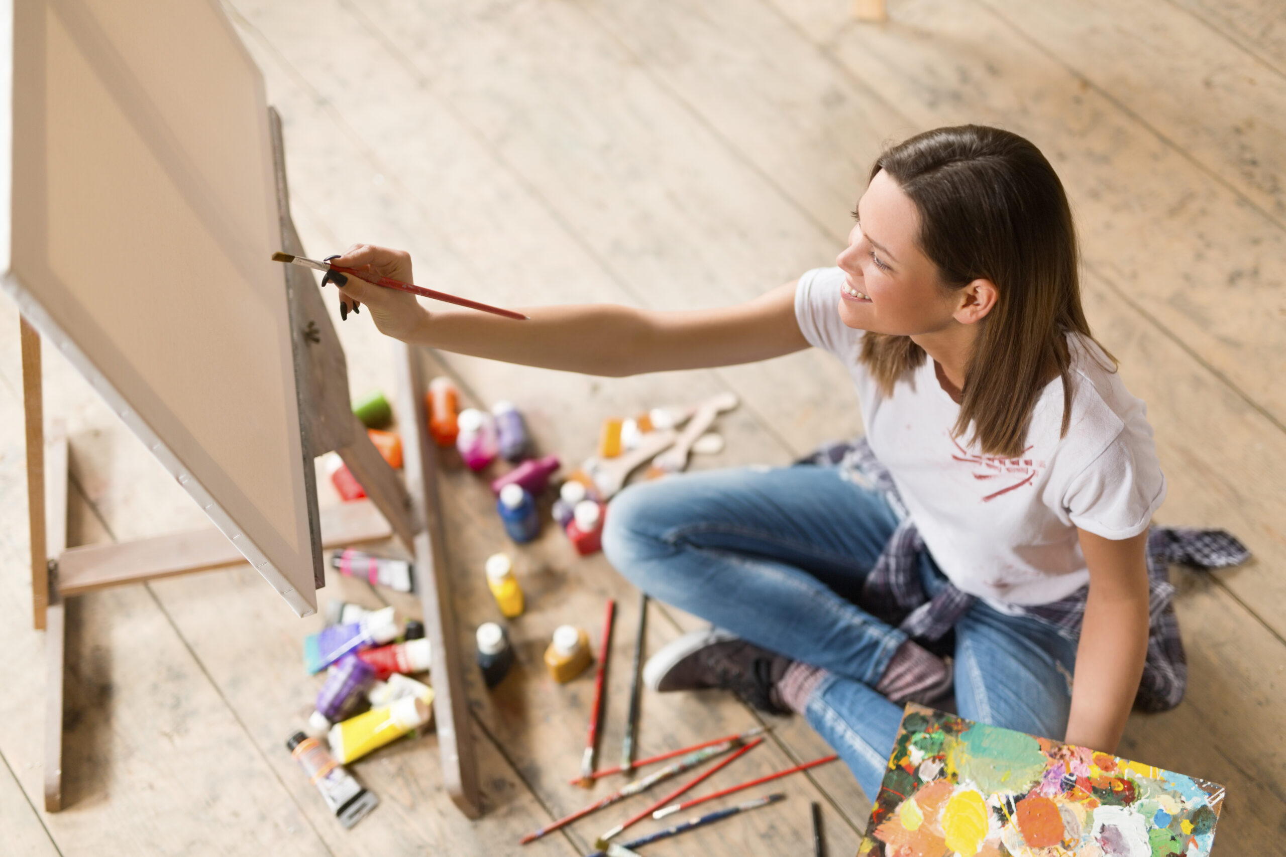 Young woman painting on canvas