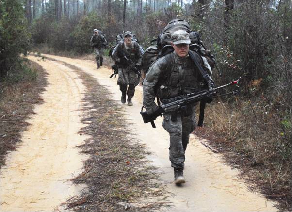 A U.S. Army student in his final week of U.S. Army Ranger School, travel a short distance on a dirt path before veering back into the forested swampland of Auxiliary Field Six at Eglin Air Force Base, Fla. His platoon hiked nearly eight kilometers through the swamp to reach their objective.