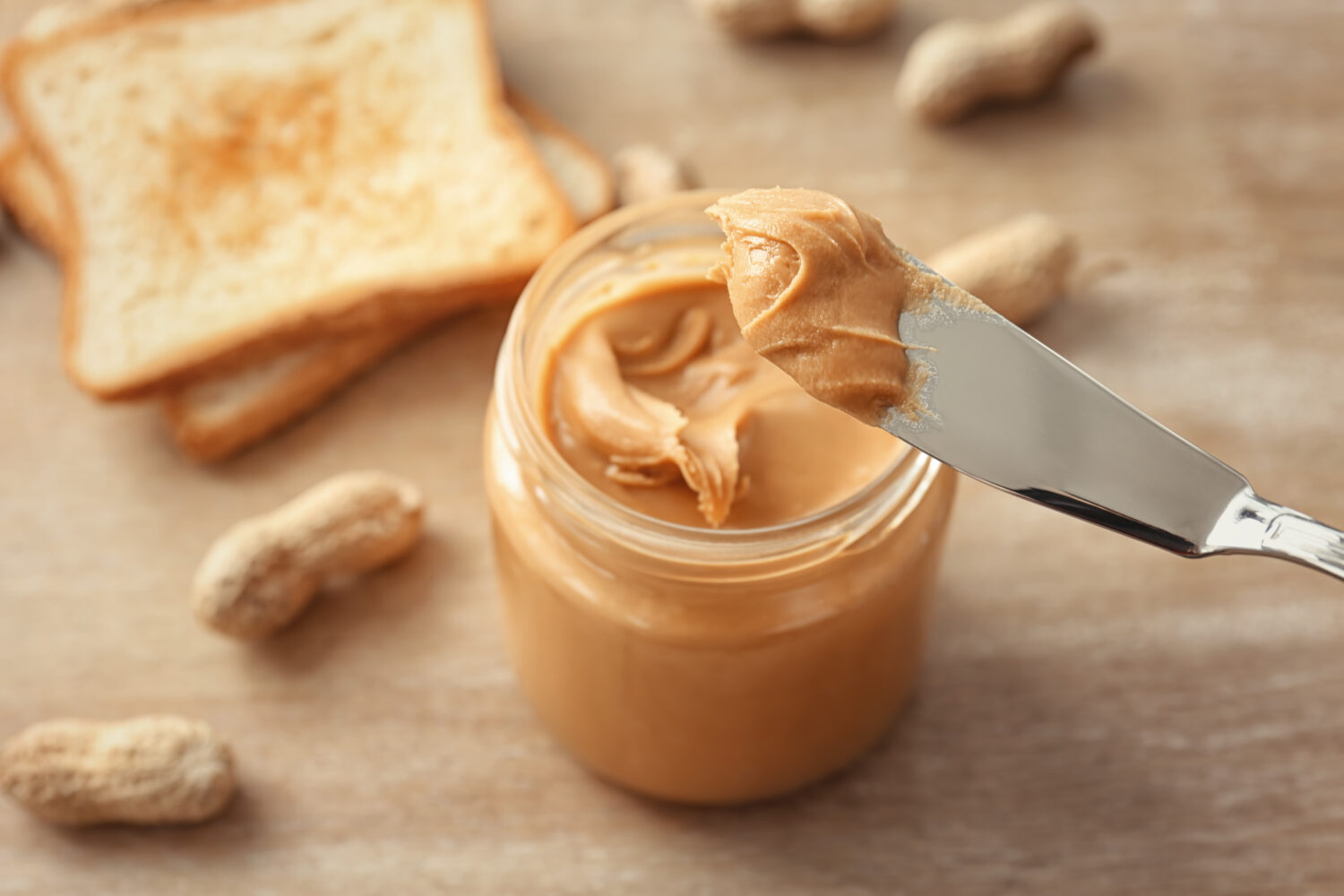 Knife with creamy peanut butter, closeup