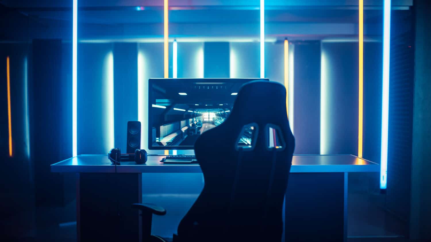 Professional Gamers Room With Ultra Powerful Personal Computer. Paused First-Person Shooter Game on Screen. Room Lit by Neon Lights in Retro Arcade Style. Cyber Sport Championship.