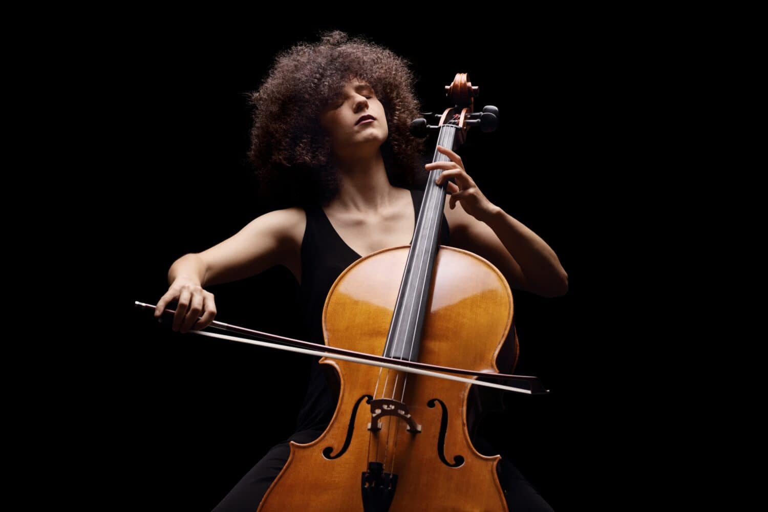 Female artist playing a contrabass isolated on black background