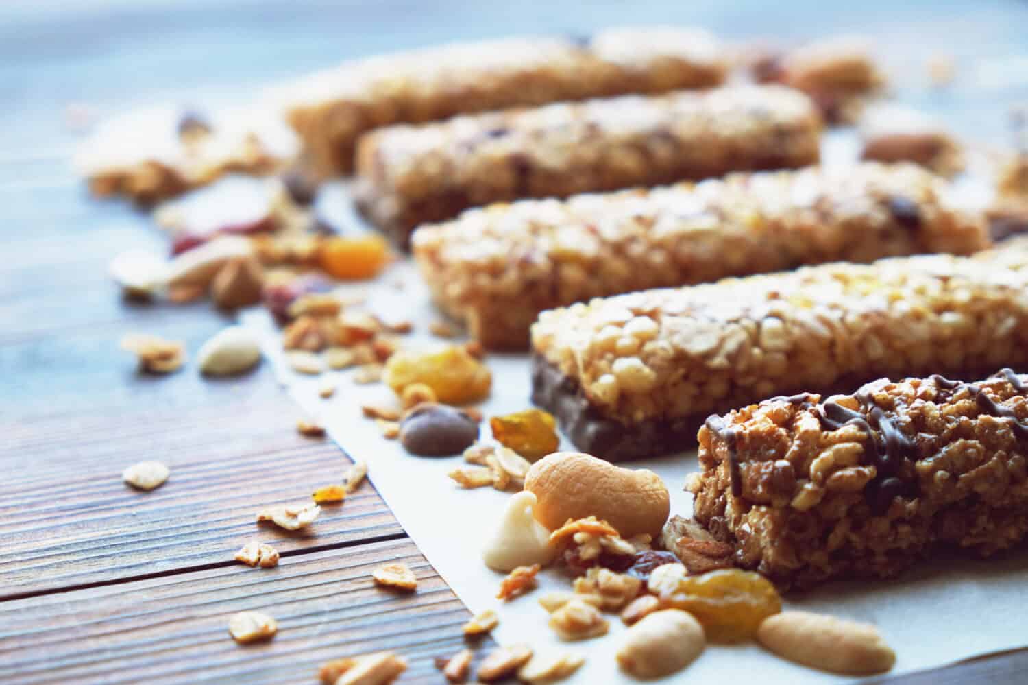 Healthy bars with nuts, seeds and dried fruits on the wooden table, with copy space.