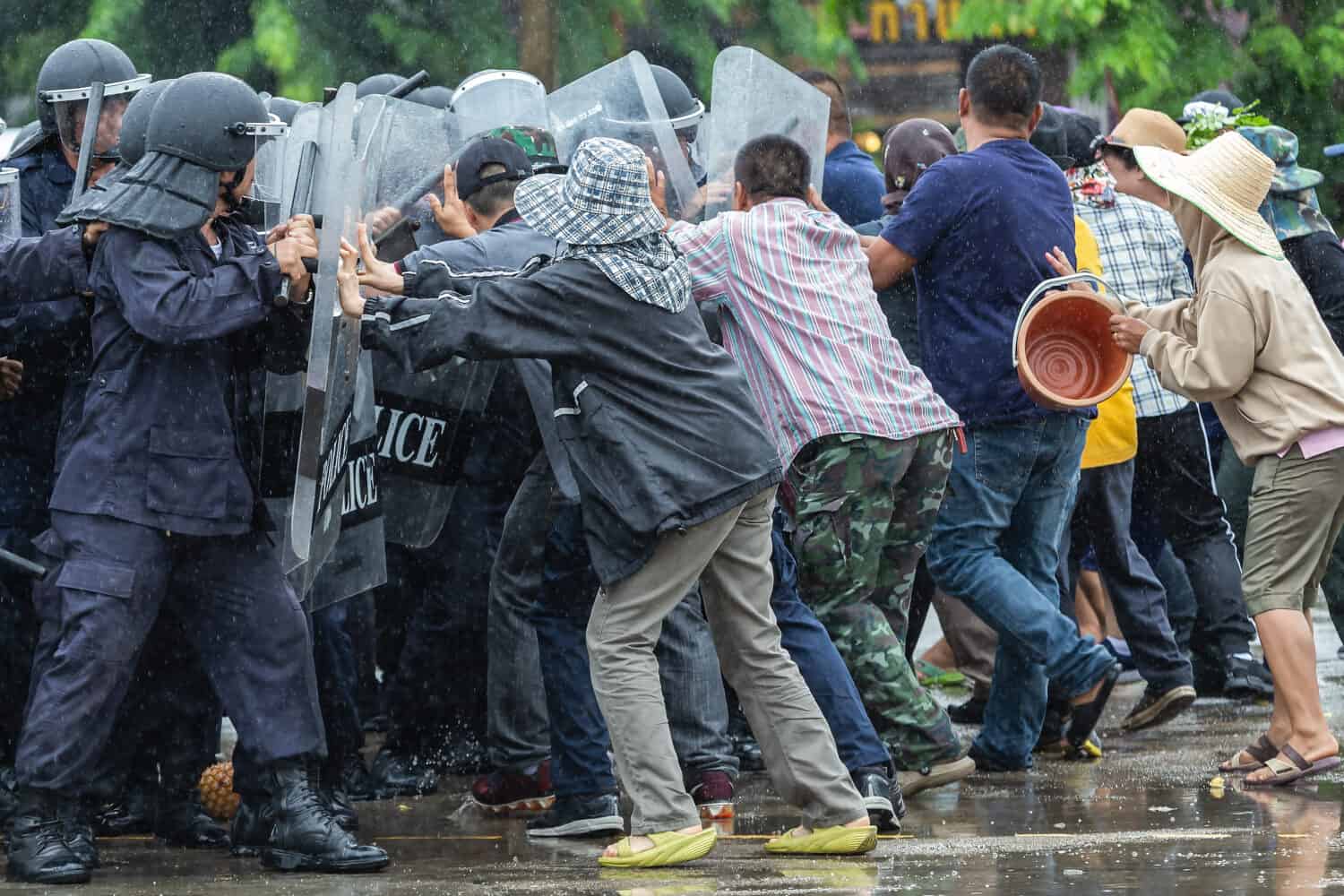 Special police unit with shields against protesters,Protester Pushes Police Riot Shields at a Political Rally.