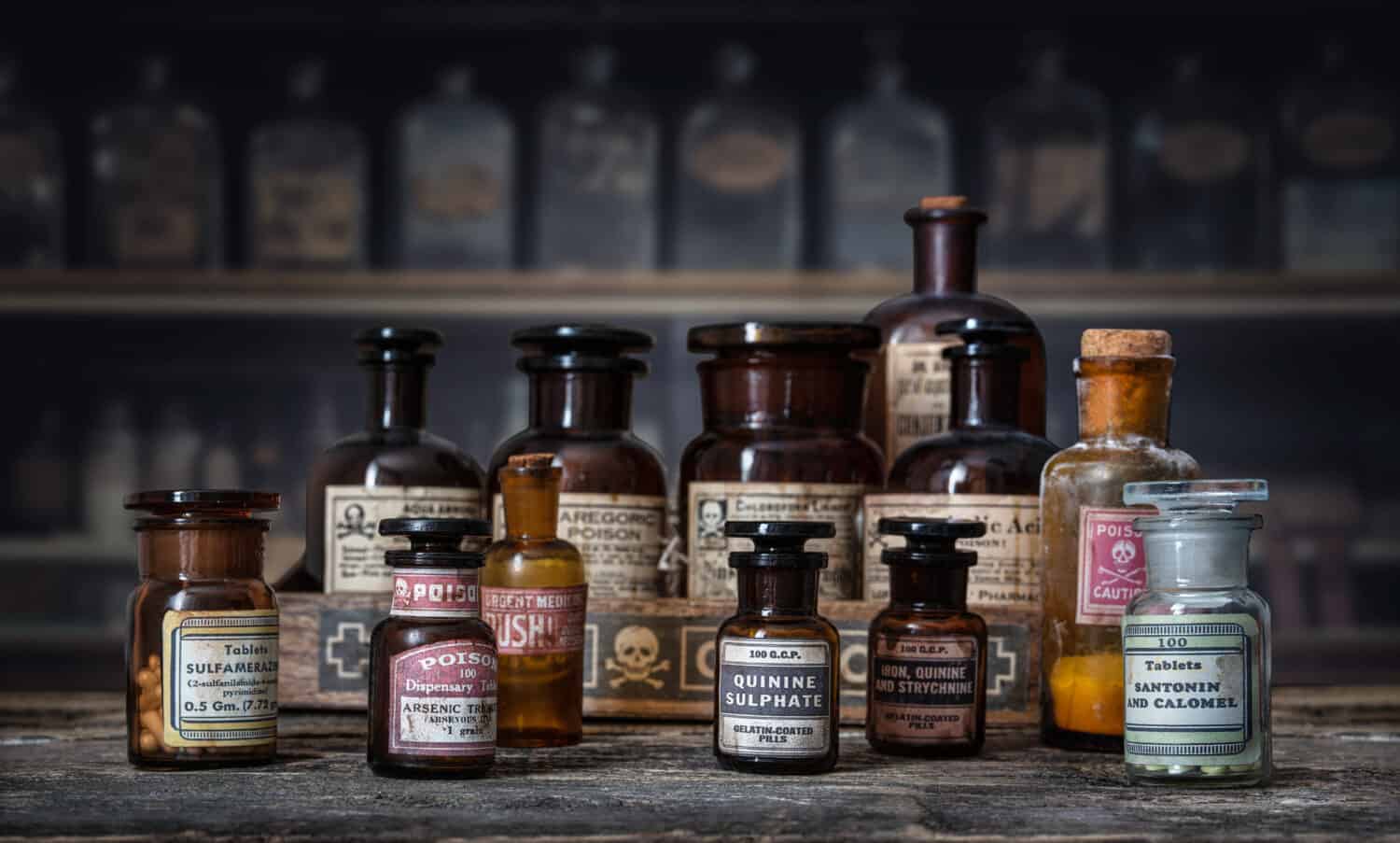 Bottles with drugs from old medical, chemical and pharmaceutical glass. Chemistry and pharmacy history concept background. Retro style. Chemical substances-sulfamerazin, arsenic trioxid etc.