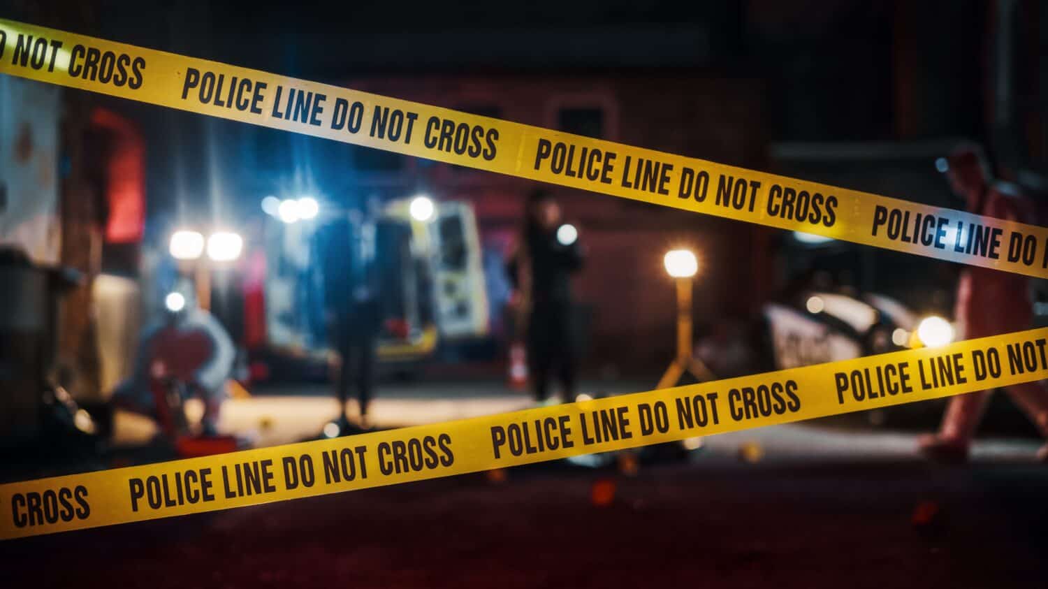 Crime Scene at Night: Crime Scene Investigation Team Working on a Murder. Female Police Officer Briefing Detective on the Victim&#039;s Body. Forensics and Paramedics Working. Cinematic Shot