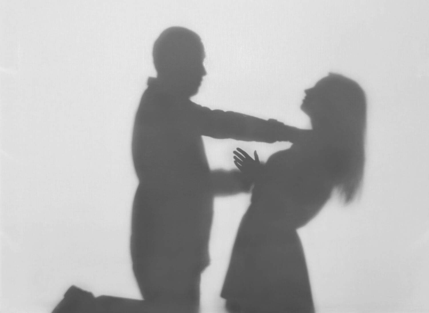 Silhouette of man trying to kill his wife on white background. Domestic violence concept