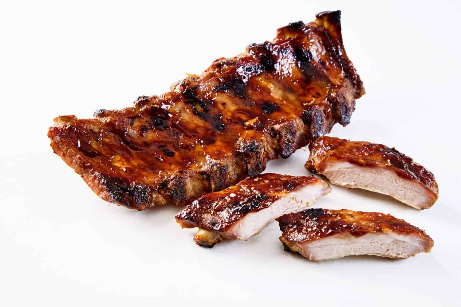 Barbecued and marinated sticky spare ribs on a white background with copy space.