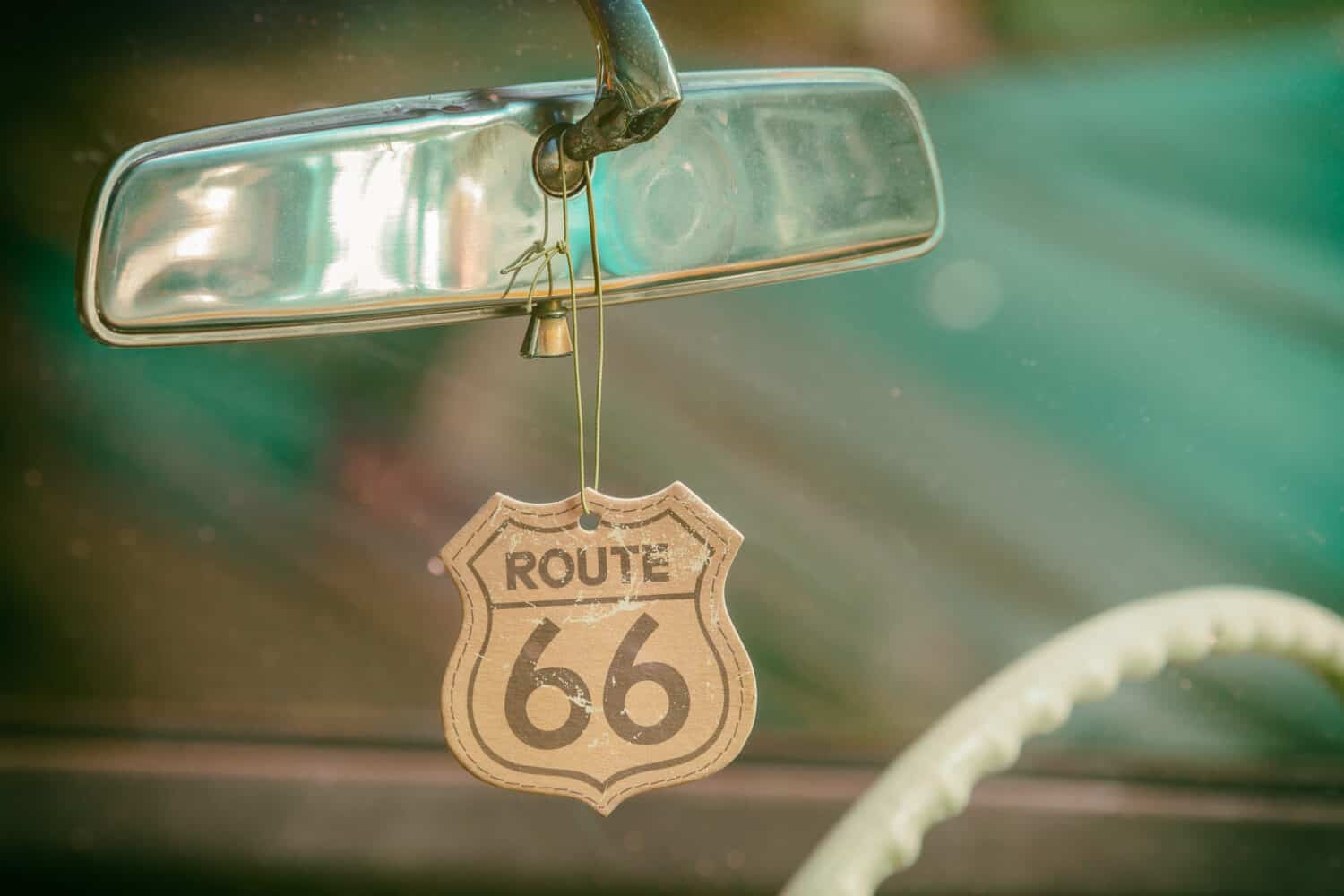 Route 66 badge hanging on a car mirror of a classic car