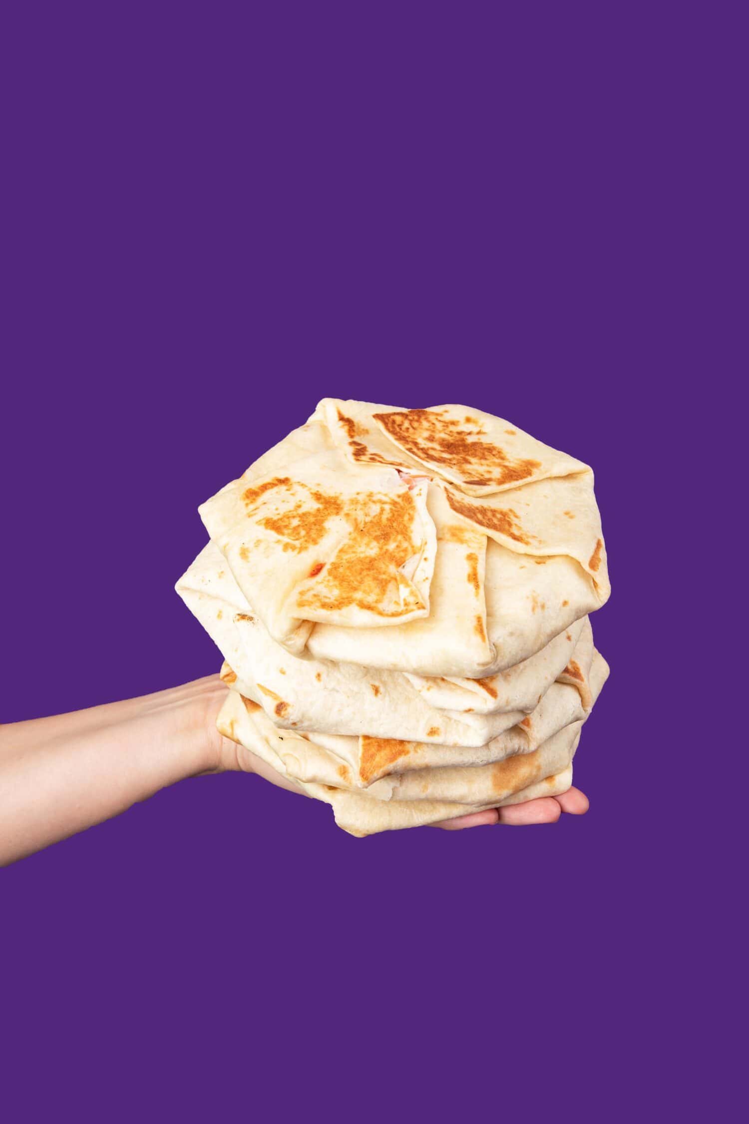 Multiple Hands holding crunchwrap supremes