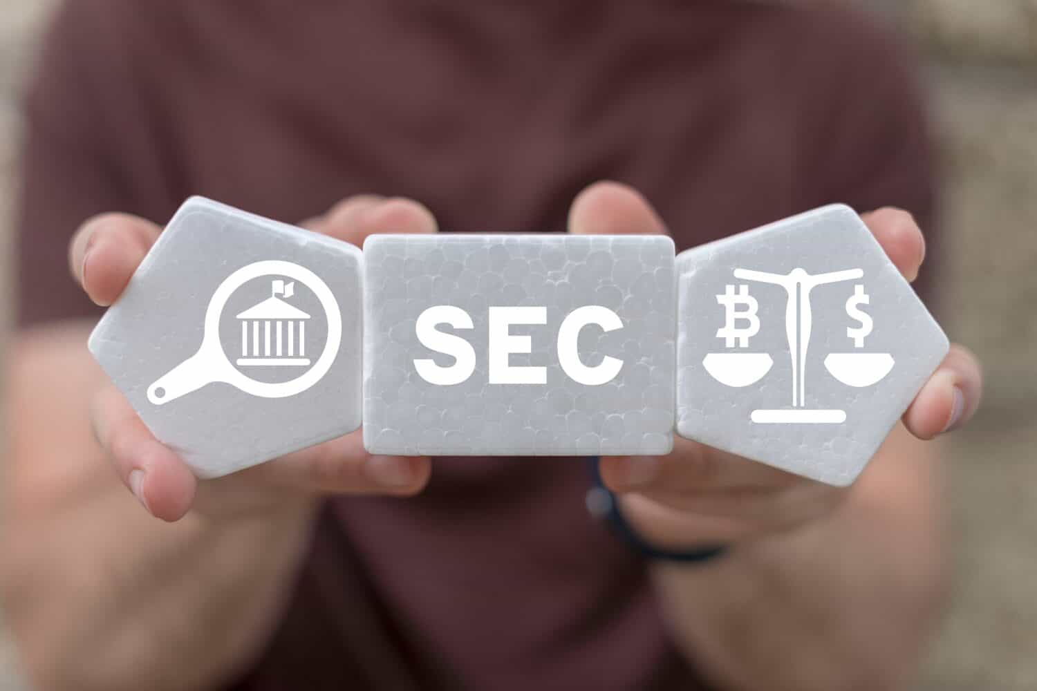 Man holding white plastic foam blocks with icons and sees acronym: SEC. Concept of Security Exchange Committee (SEC). SEC exercises control of Exchange Traded Fund (ETF).