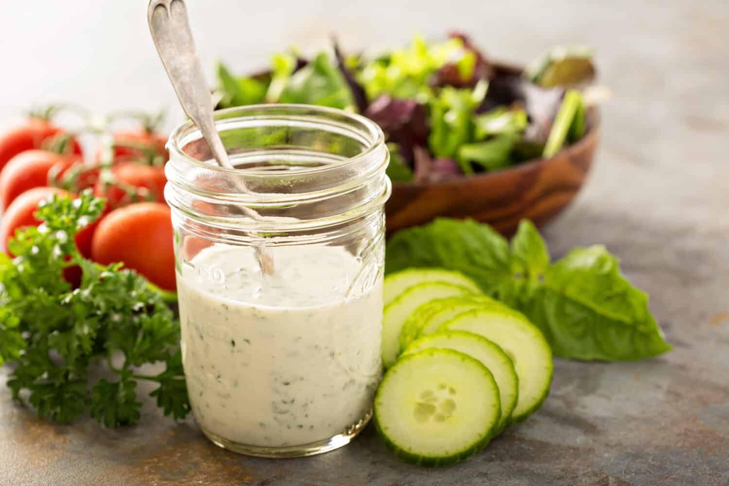 Homemade ranch dressing in a mason jar with fresh vegetables