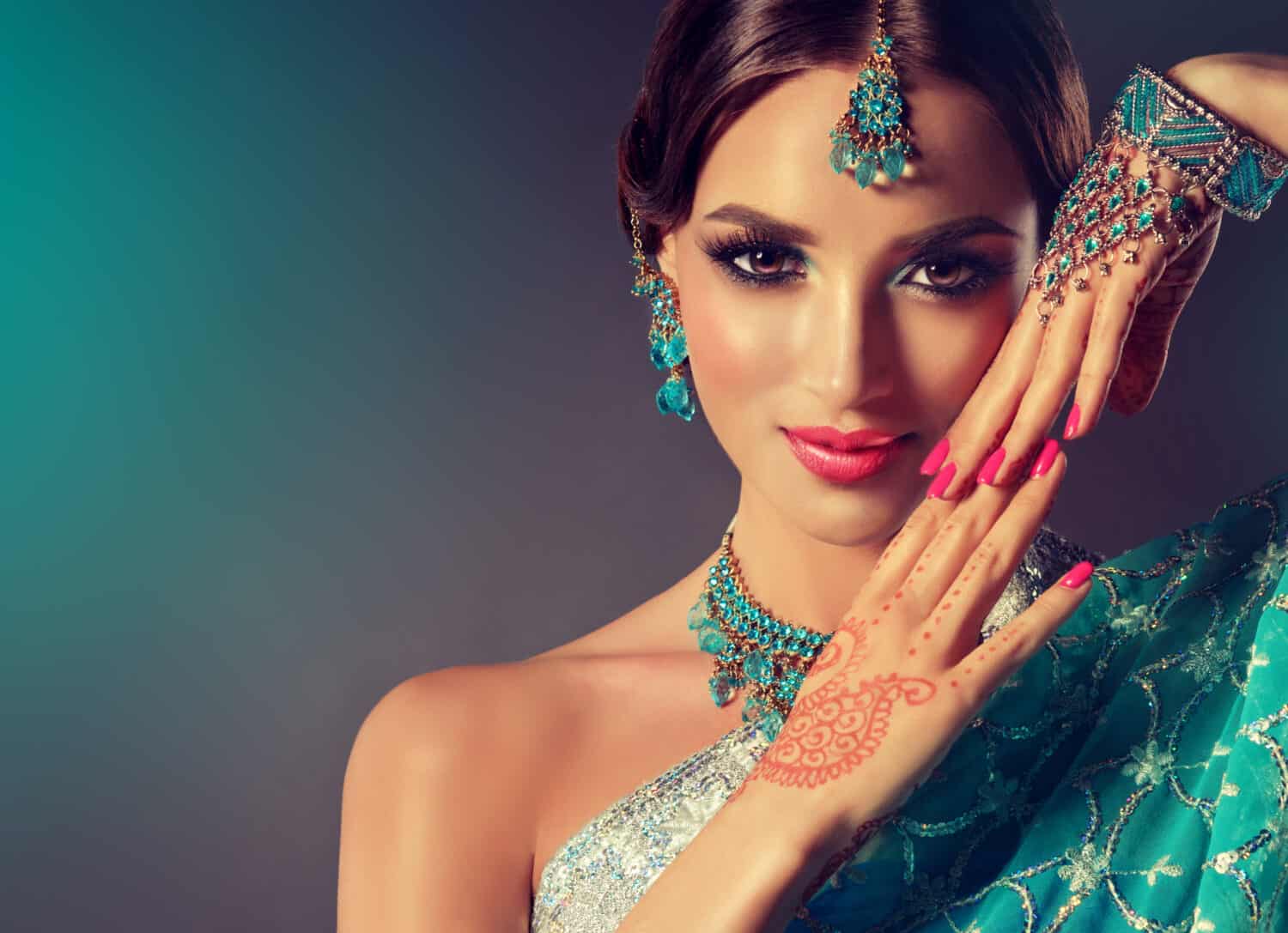 Portrait smiling of beautiful indian girl. Young indian woman model with blue jewelry set . Traditional Indian costume saree .