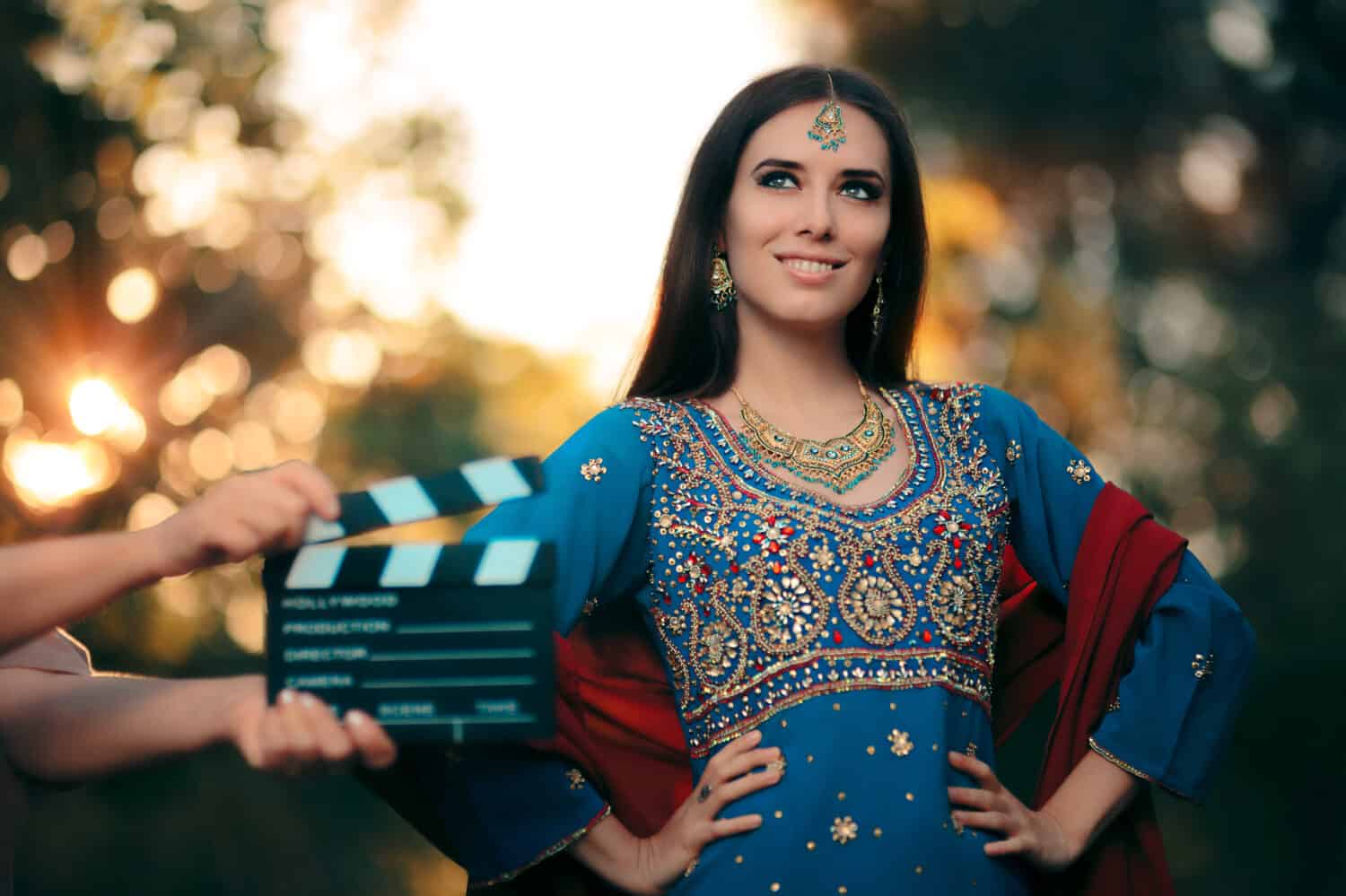 Bollywood Actress Wearing an Indian Outfit with Gold Jewelry Set - Cinema star wearing a salwar kameez with earrings, mangtika and necklace