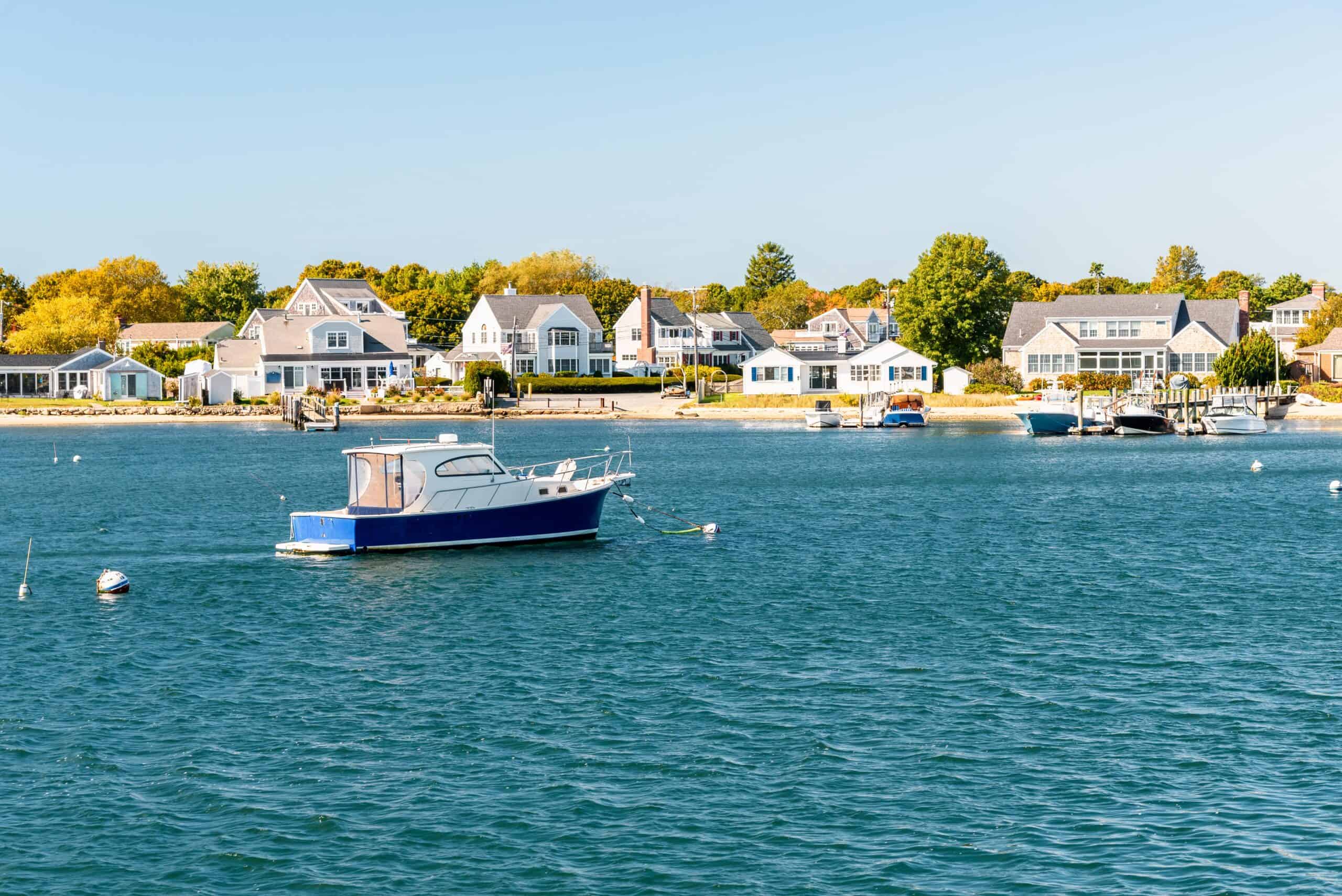 Barnstable Town, Massachusetts | Motorboat moored off a built up coast on a sunny autumn day