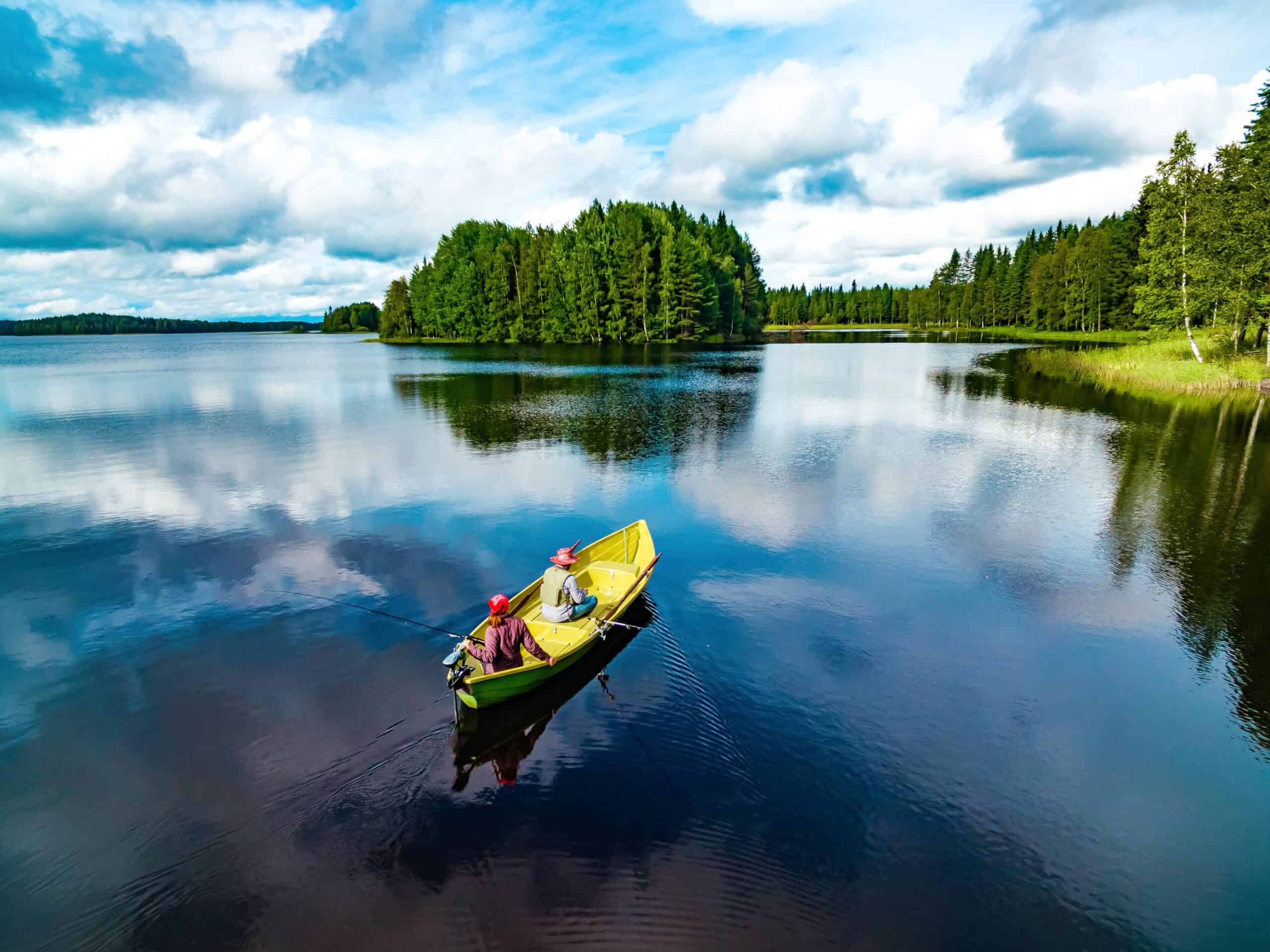 Finland | Aerial view of fishing boat with couple in blue summer lake in Finland
