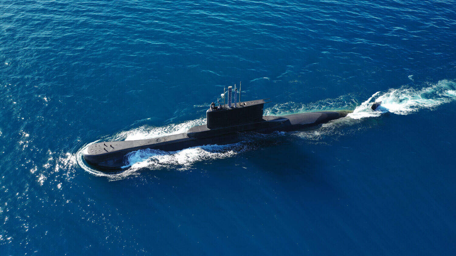 Aerial drone photo of latest technology naval armed forces submarine cruising in deep blue open ocean sea