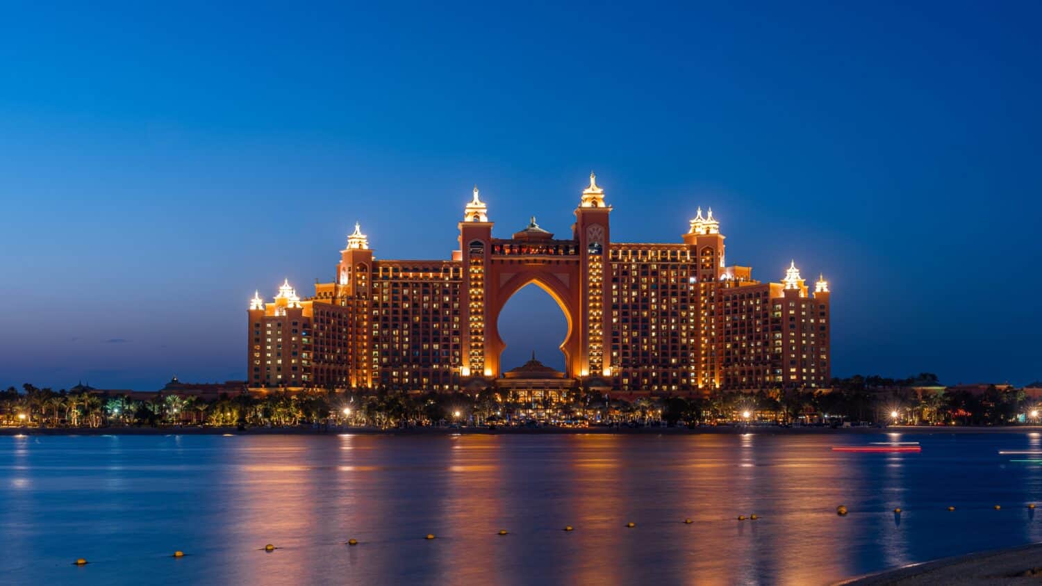 Experience the magic of Dubai&#039;s Atlantis hotel at night with our stunning landscape photograph. The iconic hotel, located on the man-made island of Palm Jumeirah