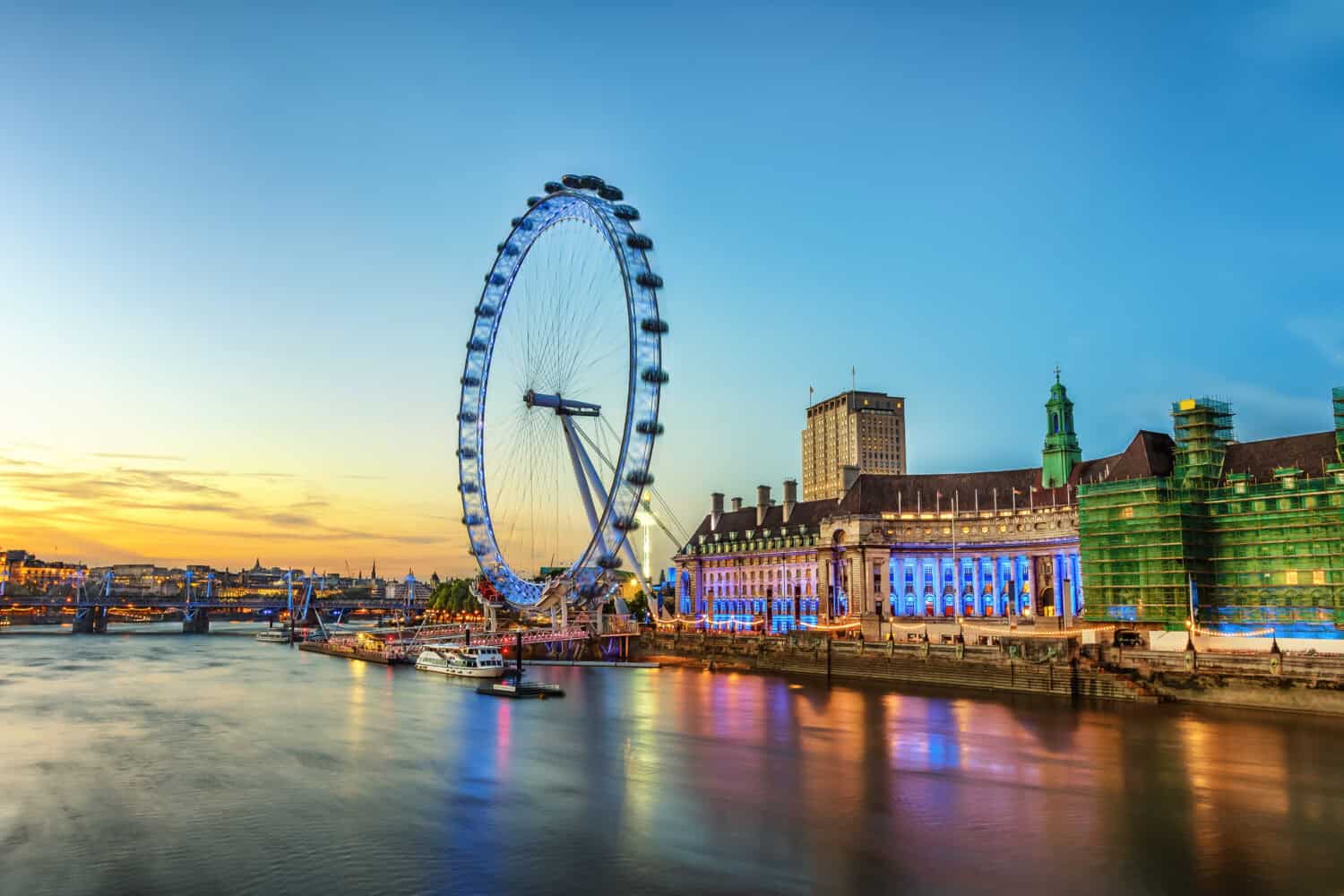 The London Eye on the South Bank of the River Thames at night in London, England.