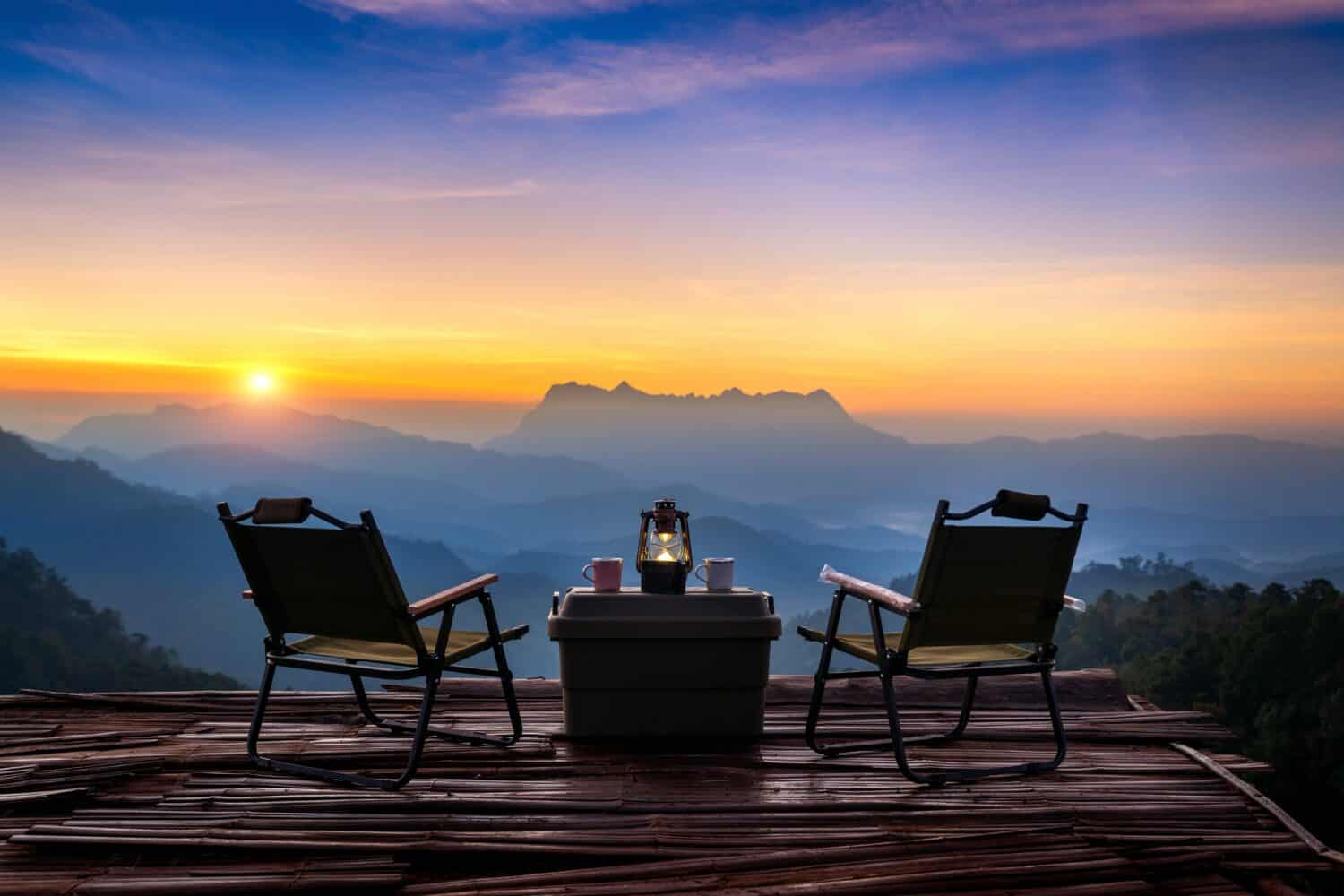 Outdoor camping table set at sunrise. Doi Luang Chiang Dao mountains in Chiang Mai.