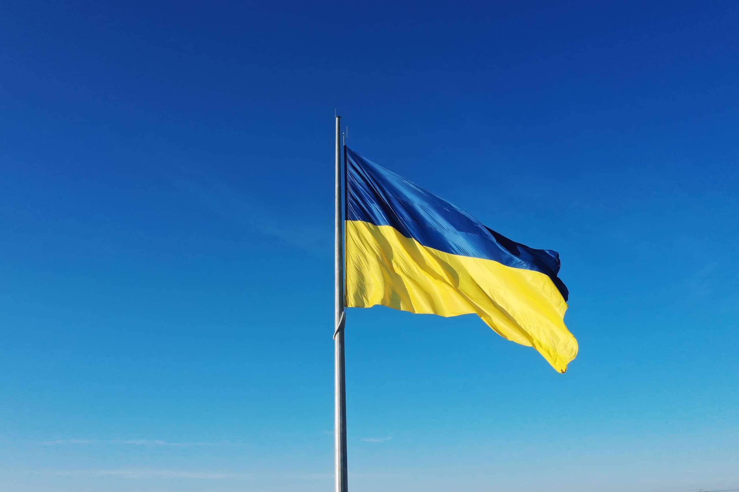 Ukraine | The flag of Ukraine develops on a flagpole against a background of clear sky