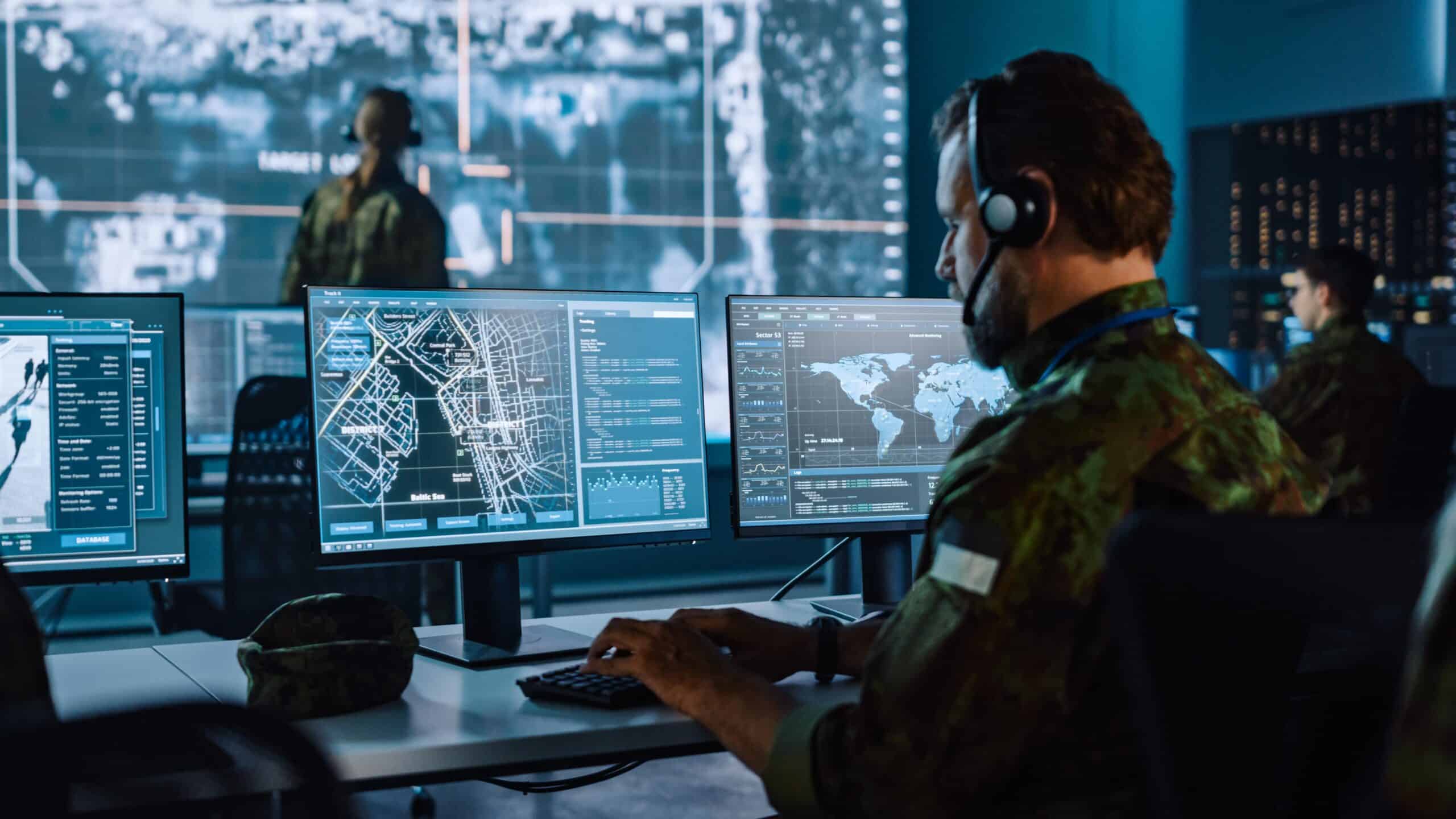 military computing | Military Surveillance Officer Working on a City Tracking Operation in a Central Office Hub for Cyber Control and Monitoring for Managing National Security, Technology and Army Communications.