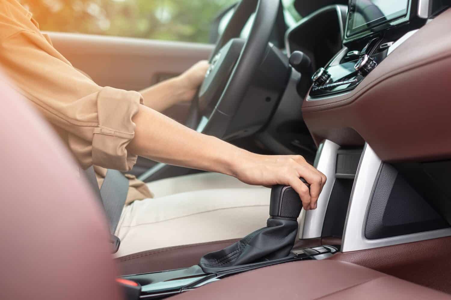 woman driver stick shift transmission a car gear, hand controlling steering wheel during vehicle moving. Journey, trip and safety Transportation concepts