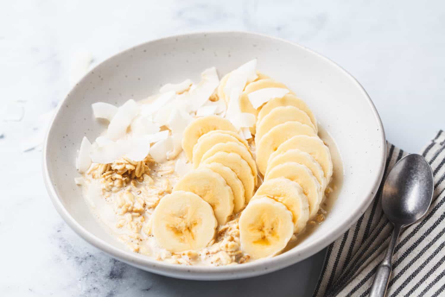 Overnight vegan oatmeal with banana and coconut chips.