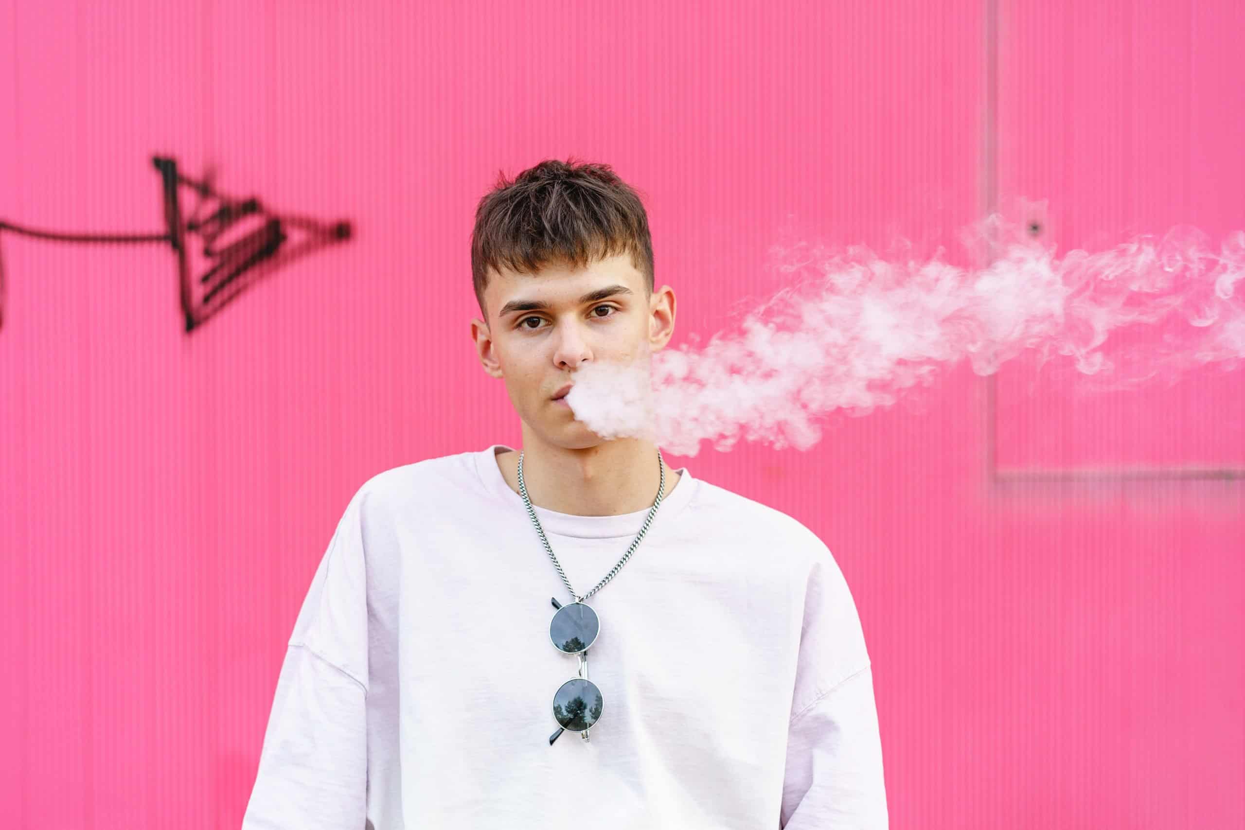 Portrait of skater hispanic man with urban style smoking outdoors.