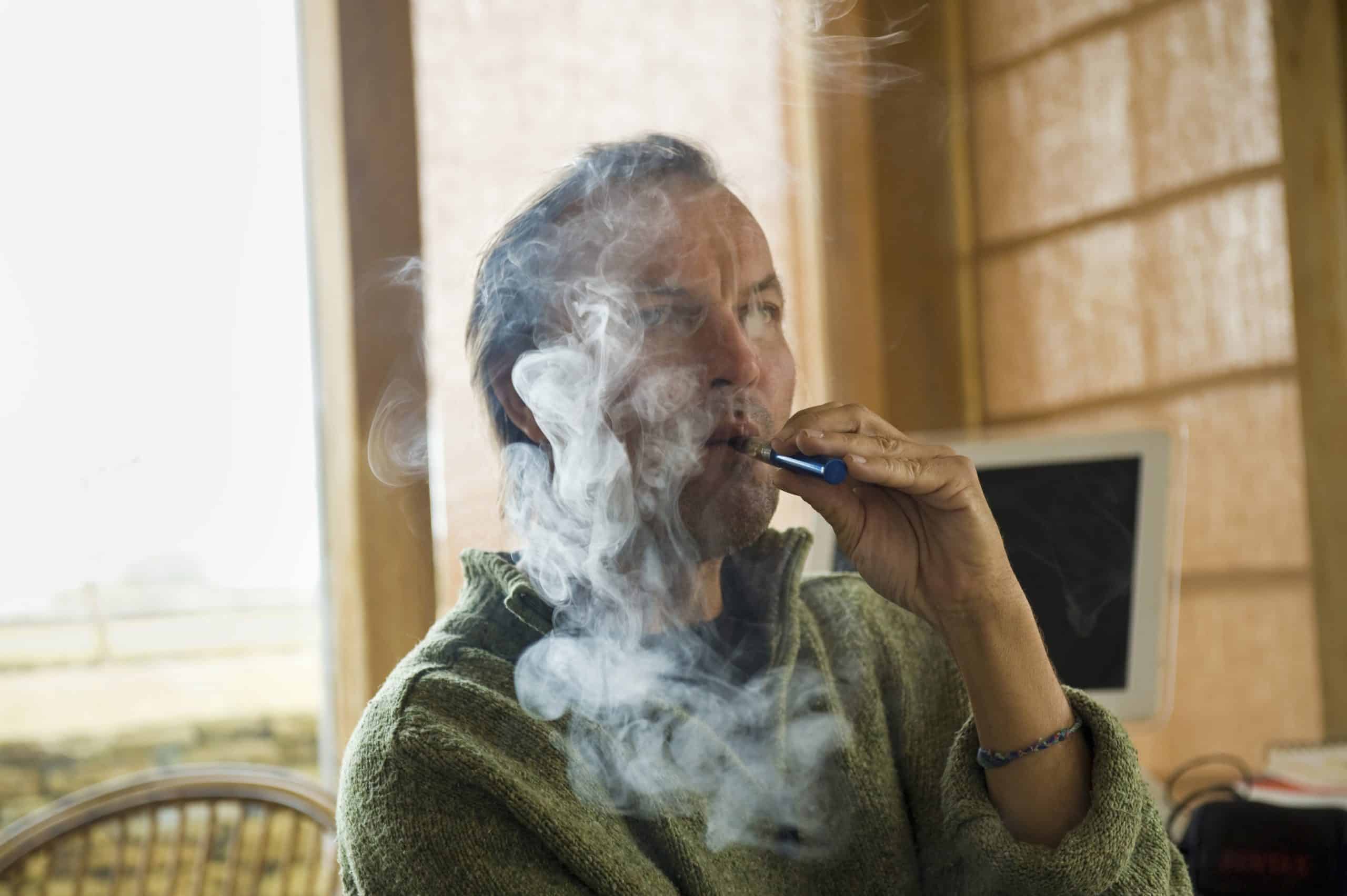 A man using an electronic cigarette, vaping.