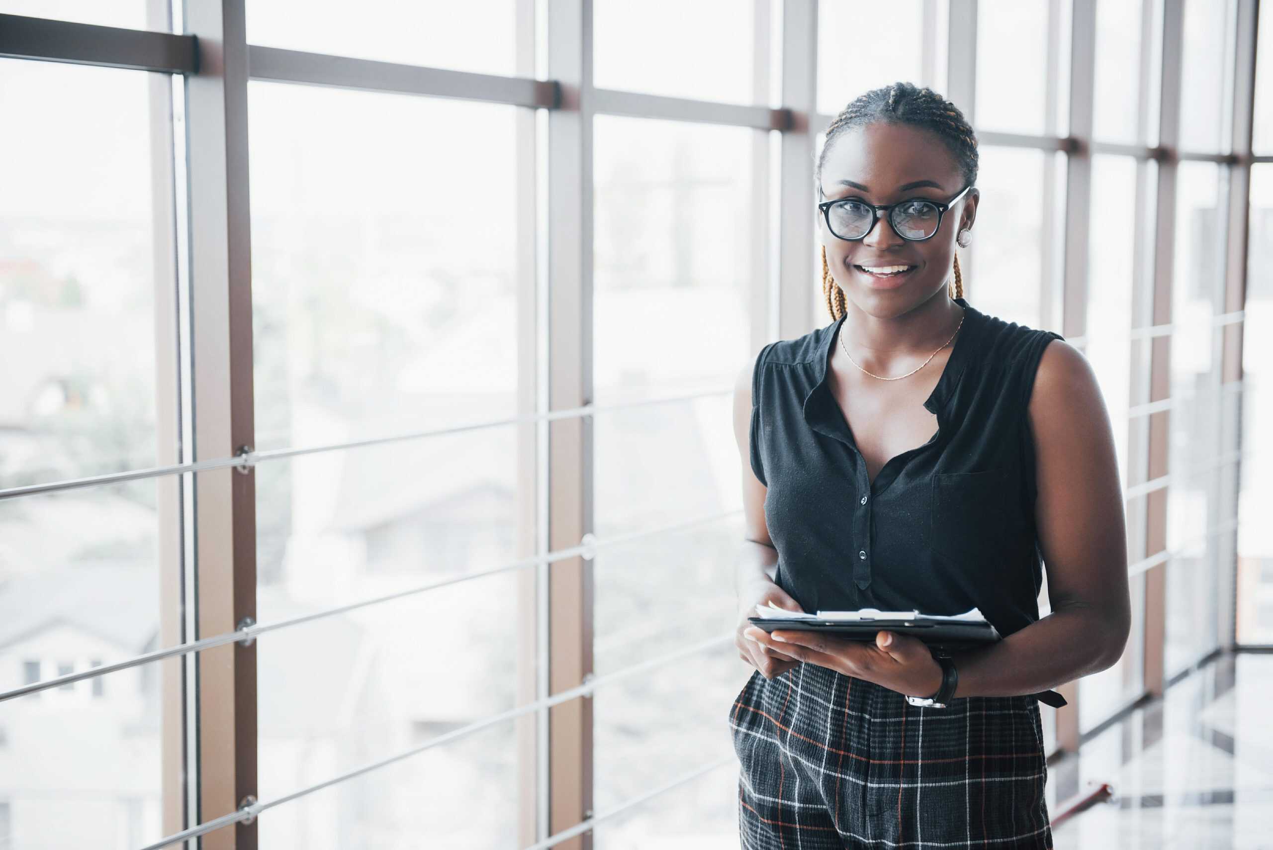 government employee | A thoughtful African American business woman wearing glasses holding documents