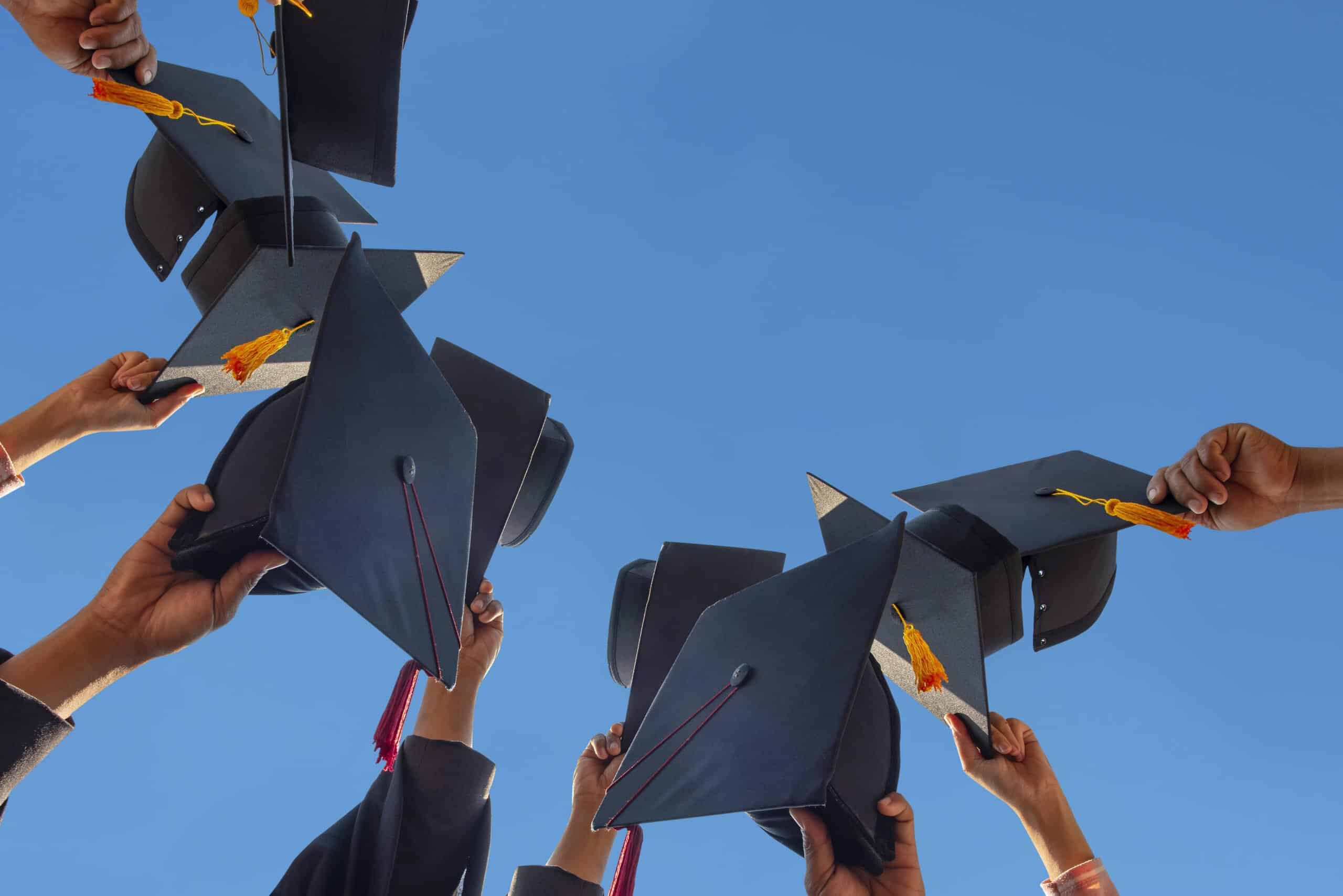 high school graduation | The students holding a shot of graduation cap by their hand in a bright sky during ceremony success graduates at the University, Concept of Successful Education in Hight School,Congratulated Degree