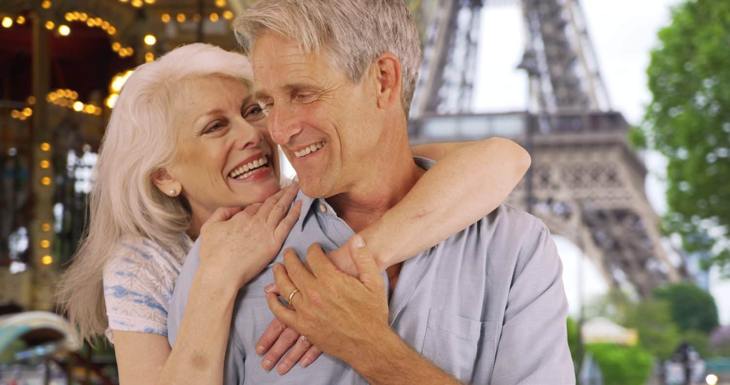 Affectionate senior husband and wife embracing near the Eiffel Tower