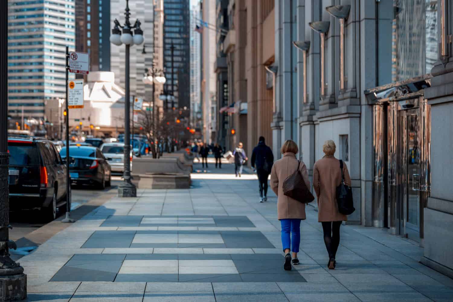 Woman walking down a busy street in downtown Chicago on a cool autumn morning