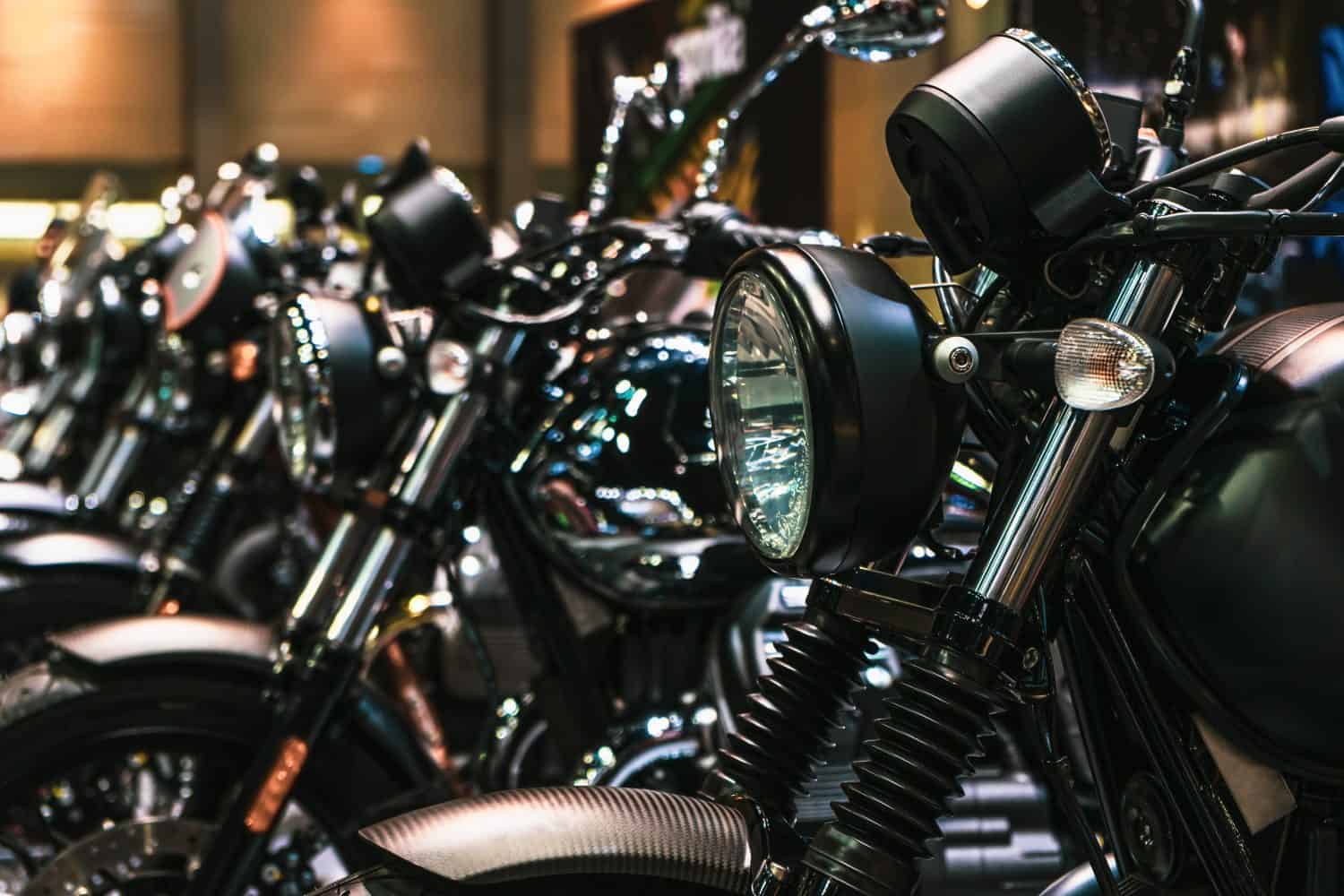 Close up detail of Headlights and chrome parts of motorbikes, brand new motorcycles parked in a row, in a motorbike dealership. Shallow depth of field.