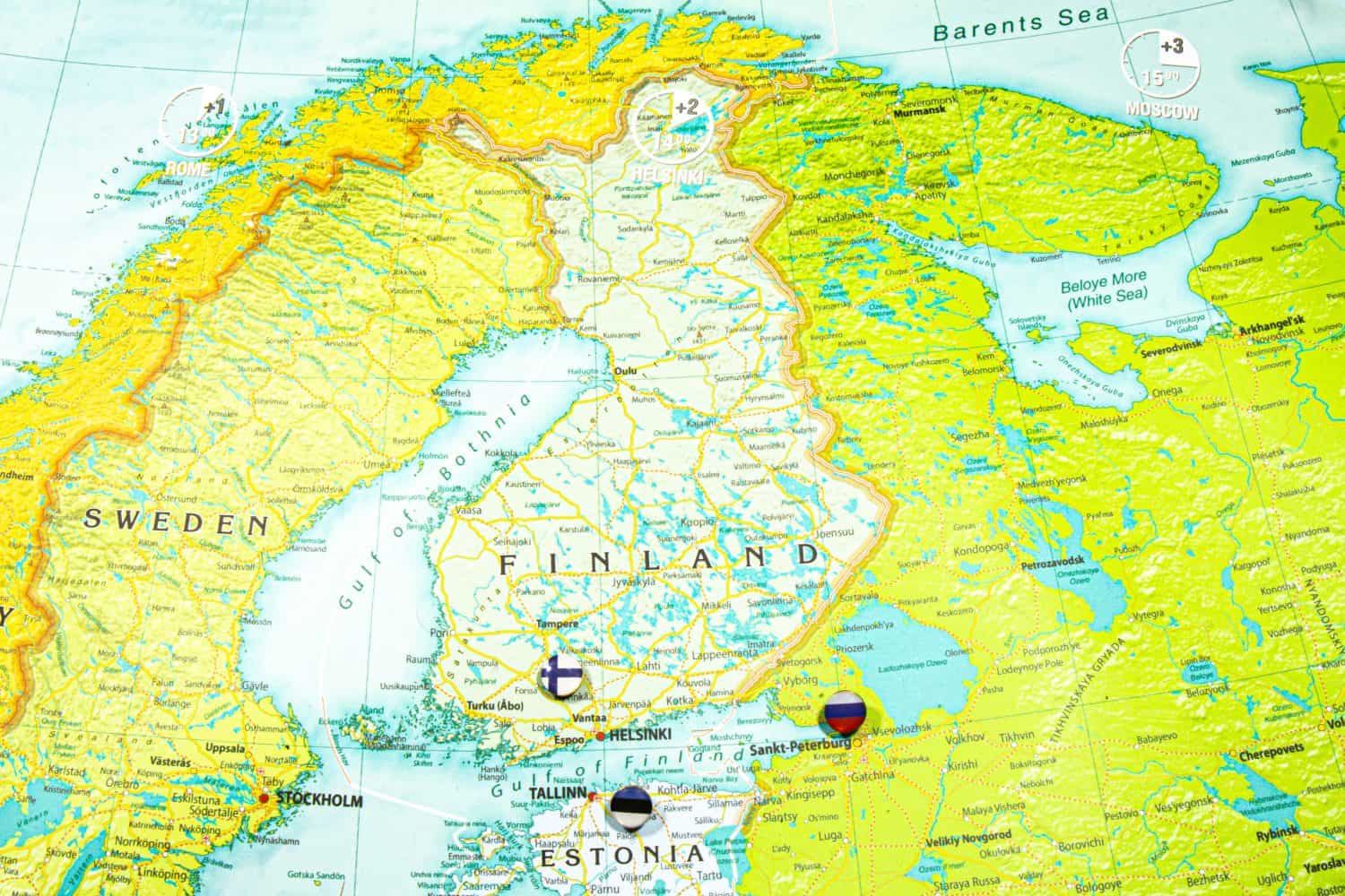 Finland national flag pinned on Europe map. Macro Close up picture of country on a colorful and Blurry World Map Globe with focus to capital Helsinki. Push pin on map, marker of destination.