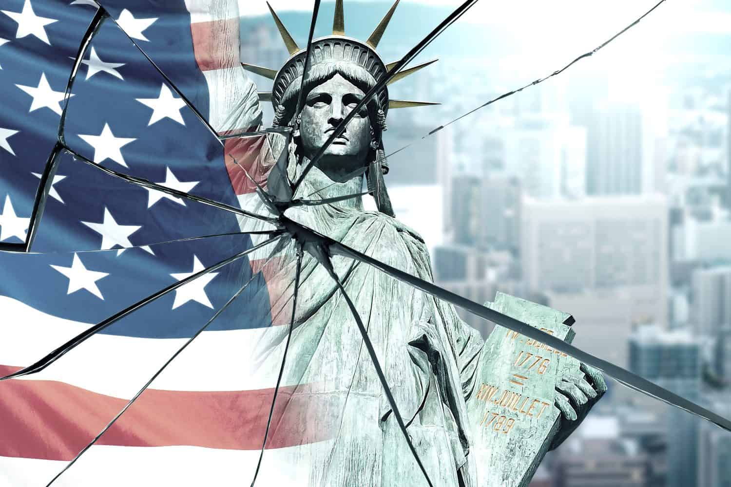 The statue of freedom is deteriorated in a broken mirror. Cracks on the glass with a reflection of the flag of the United States of America. The concept of economic and political problems in the USA