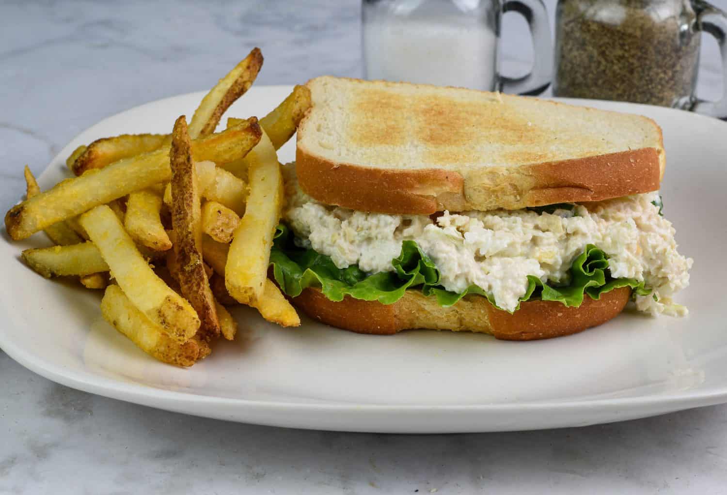 chicken salad sandwich served with a side of fries