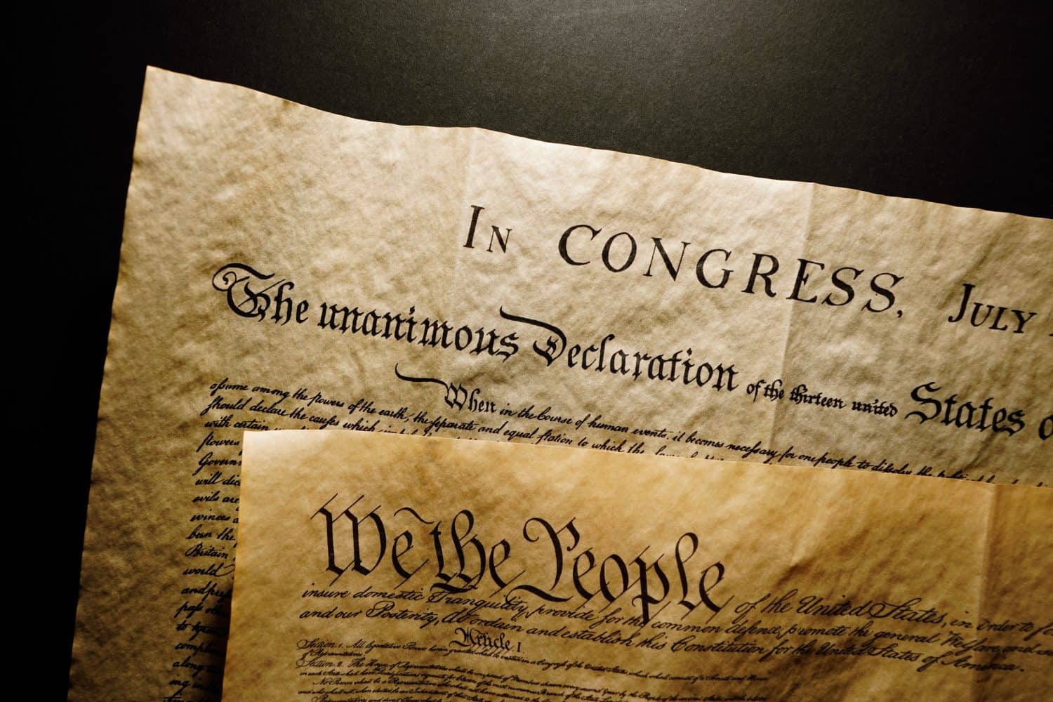 Pages of the United States Constitution showing We The People heading and Declaration of Independence.